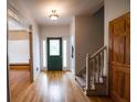 Bright entryway with hardwood floors, stairs, and green door at 3598 Brock Rd, Duluth, GA 30096