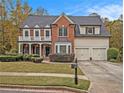 Brick two-story house with three-car garage and landscaped yard at 4835 Trilogy Park Trl, Hoschton, GA 30548