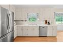 Bright kitchen with white cabinets, stainless steel appliances, and hardwood floors at 5892 Smoke Rise Ct, Stone Mountain, GA 30087
