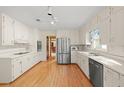 Spacious kitchen featuring white cabinets, stainless steel appliances, and hardwood floors at 5892 Smoke Rise Ct, Stone Mountain, GA 30087