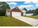 Brick ranch home with attached garage and driveway at 1712 Graystone Dr, Hampton, GA 30228