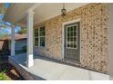 Front porch with brick columns and a gray door at 2126 Seavey Dr, Decatur, GA 30032