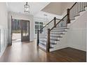 Bright and spacious foyer with hardwood floors, staircase, and elegant light fixture at 234 Aberdeen Way, Woodstock, GA 30188