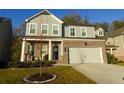 Two-story home with brick and siding, a two-car garage, and a landscaped front yard at 573 Auburn Crossing Dr, Auburn, GA 30011