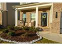 Brick front porch with seating area and landscaping at 573 Auburn Crossing Dr, Auburn, GA 30011