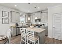 Modern kitchen with gray cabinets, granite countertops, and stainless steel appliances at 516 Lanier Way, Temple, GA 30179