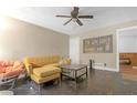 Living room featuring a mustard-colored sectional sofa and ceiling fan at 2314 Omaha Sw Rd, Atlanta, GA 30331