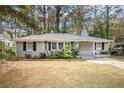 Newly painted gray brick ranch home with a red door and landscaped lawn at 2435 Wood Valley Dr, Atlanta, GA 30344
