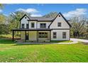 Two-story farmhouse with white siding, black accents, and a covered porch at 2788 Browns Mill Se Rd, Atlanta, GA 30354