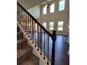 Elegant staircase with wrought iron railing leading to an open living area at 1117 Kingston Hill Dr, Loganville, GA 30052