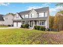 Two-story house with a large front yard, attached two-car garage, and vinyl siding at 4911 Crinklepoint Ct, Douglasville, GA 30134