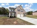 Two-story brick house with three-car garage and driveway at 6788 Oconee Pl, Fairburn, GA 30213