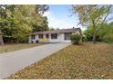 White ranch home with a long driveway and mature trees at 200 Sunrise Cir, Riverdale, GA 30274