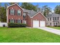 Two-story brick home with a three-car garage and landscaping at 6257 Selborn Sw Dr, Atlanta, GA 30331