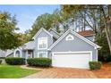 Two-story house with gray siding, a white garage door, and landscaping at 949 Heartwood Cir, Lawrenceville, GA 30043