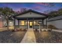 Renovated cottage with a welcoming front porch at dusk at 923 Smith Sw St, Atlanta, GA 30310