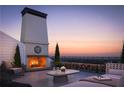 Rooftop terrace with fireplace, seating area, and city views at 625 Mayfair Ct, Alpharetta, GA 30009