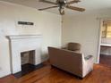 Living room with hardwood floors, fireplace, and ceiling fan at 6848 Church St, Lithonia, GA 30058