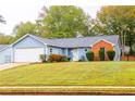 Ranch home with attached garage and landscaped yard at 1121 Whisper Wind Dr, Mcdonough, GA 30253