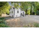 White house with gray steps, gravel driveway and mature trees at 3775 Clairmont Rd, Chamblee, GA 30341