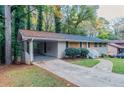 Ranch home with carport and driveway, surrounded by lush greenery at 2648 Cavalier Dr, Decatur, GA 30034