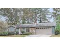 One-story home with gray siding, stone accents, and attached garage at 1057 Sawgrass Sw Ct, Lilburn, GA 30047