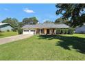 Ranch-style home with two-car garage and landscaped lawn at 107 Gwenellen Dr, Locust Grove, GA 30248