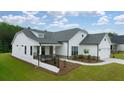 White farmhouse exterior with gray roof, landscaping, and a paved driveway at 3719 Tielman St, Snellville, GA 30078