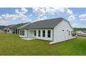 View of the home's back, showcasing a patio and grassy yard at 3719 Tielman St, Snellville, GA 30078