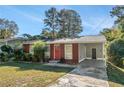 Cute brick ranch house with a red door, and a grassy yard at 2648 Santa Monica Nw Dr, Atlanta, GA 30318