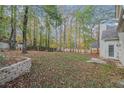 Large backyard with trees and a stone retaining wall at 114 Arborwood Way, Temple, GA 30179