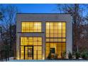 Modern home with illuminated windows and a brick exterior at twilight at 247 Huntington Ne Rd, Atlanta, GA 30309