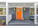 Inviting front porch with an orange door and gray brick exterior at 1138 Bouldercrest Se Dr, Atlanta, GA 30316