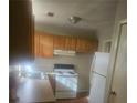 Galley kitchen with wood cabinets and white appliances at 1935 Akron Se Dr, Atlanta, GA 30315