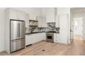 Modern kitchen features stainless steel appliances and white shaker cabinets at 1184 Lupo Loop, Chattahoochee Hills, GA 30268