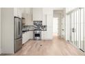 Modern kitchen with stainless steel appliances and light wood floors at 1184 Lupo Loop, Chattahoochee Hills, GA 30268