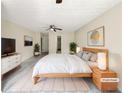 Virtually staged main bedroom with large bed and TV at 3781 Harvest Dr, Decatur, GA 30034