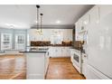 Updated kitchen with white cabinets, granite island and tile backsplash at 2527 Sky Valley Dr, Dacula, GA 30019