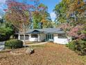 Ranch home with white siding, black garage door, and landscaping at 513 Duke Dr, Marietta, GA 30066
