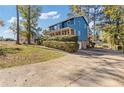 Two-story blue house with a large driveway and well-manicured lawn at 3885 Willow Ridge Ct, Douglasville, GA 30135