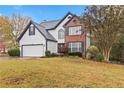 Two-story house with white siding, brick accents, and a two-car garage at 1320 Platinum Dr, Hoschton, GA 30548