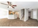 Open-concept living and dining area with wood-look tile flooring and a staircase at 611 Shadow Valley Ct, Lithonia, GA 30058