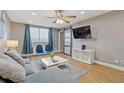 Bright living room with a large TV, comfy couch, and ceiling fan at 215 Piedmont Ne Ave # 2003, Atlanta, GA 30308