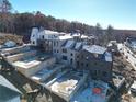 Luxury homes under construction on a hillside with wooded backdrop at 10935 Serenbe Ln, Chattahoochee Hills, GA 30268