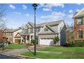 Two-story house with a three-car garage, well-maintained lawn, and mature trees at 1428 Sparkling Cove Dr, Buford, GA 30518
