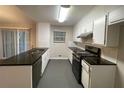 Galley kitchen with granite countertops and stainless steel appliances at 5914 Sara Ashley Ct, Lithonia, GA 30058