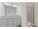 Bathroom featuring dual vanities, granite countertop, and a tiled shower at 835 Pensive Run, Dacula, GA 30019