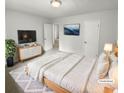 Virtually staged main bedroom with white bedding and a TV at 5876 Poplin Ct, Lithonia, GA 30058
