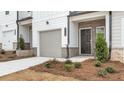 Townhome features a dark brown door and gray garage door at 212 Kenoot Dr, Mcdonough, GA 30253