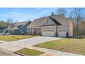 Two-story house with gray siding, stone accents, and a three-car garage at 63 Black Rock Rdg, Sharpsburg, GA 30277